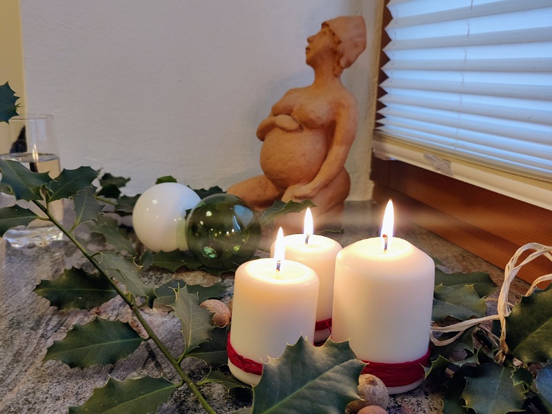 3 Kerzen und eine schwangere Frau aus Ton